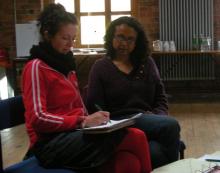 Two participants completing an action plan as part of the Strong Roots workshop